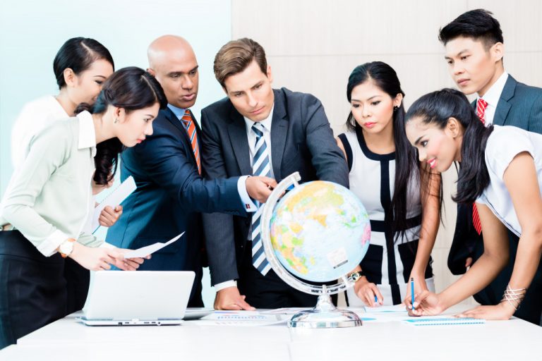 Executives checking a globe to see where to expand its market.