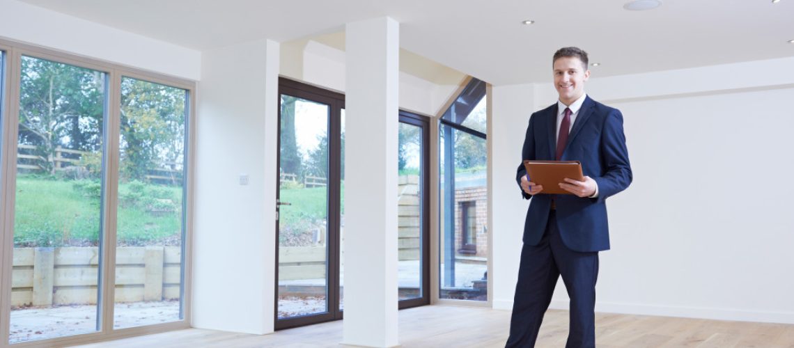 real estate agent standing inside a property for sale